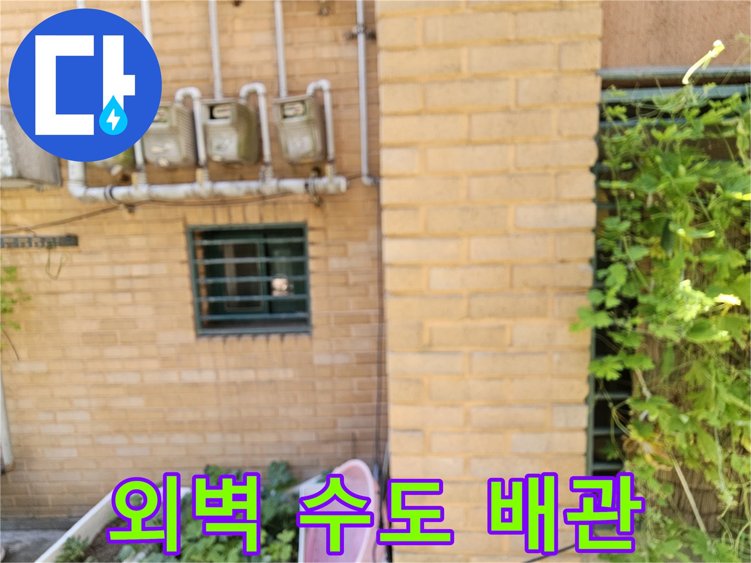 수도 계량기와 벽돌 외벽에 연결된 배관의 모습