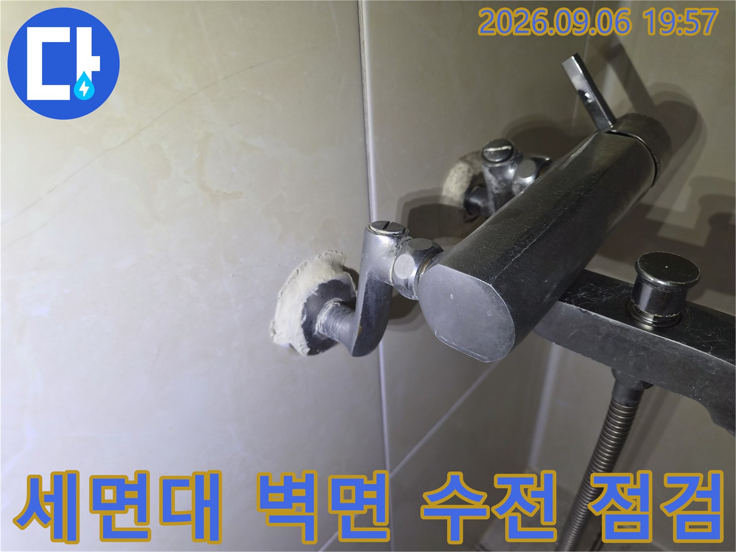 벽면에 설치된 세면대용 수전과 연결 배관의 모습을 담은 사진입니다.
