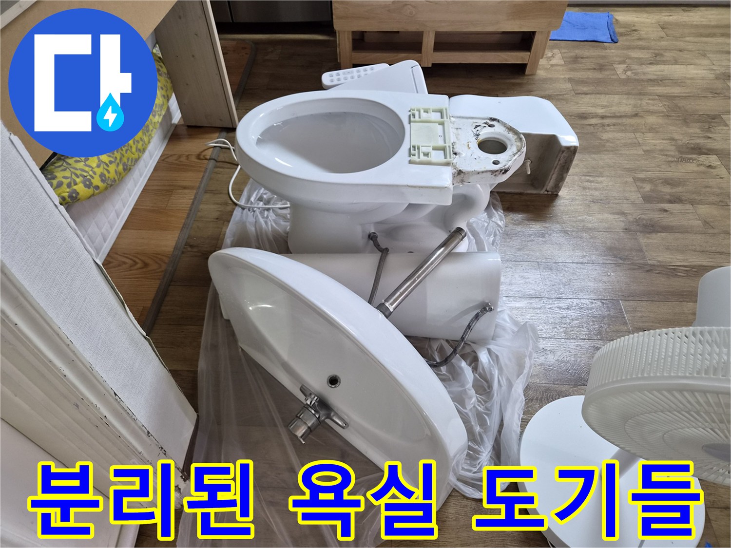 화장실 바닥에 내려놓은 탈거된 양변기와 세면대 사진입니다.
