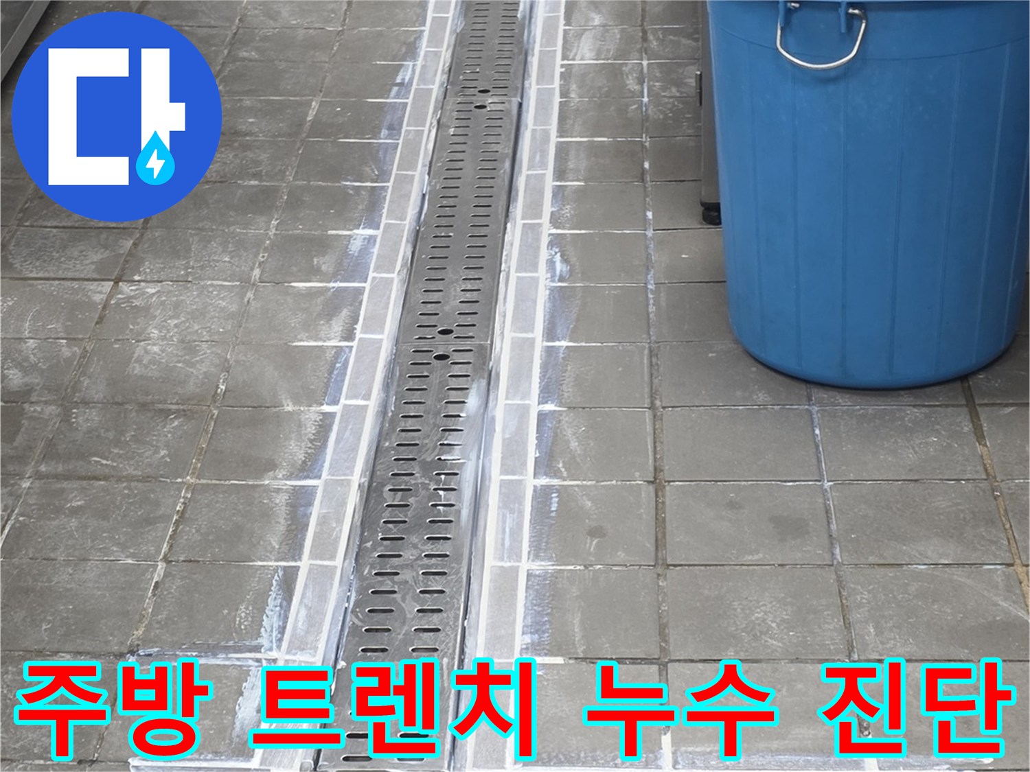 스테인리스 소재의 배수 트렌치와 바닥 타일 마감 부위 근접 촬영