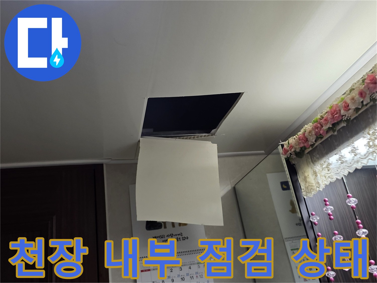 누수 진단을 위해 천장 점검구를 열어 배관을 확인하고 있습니다.