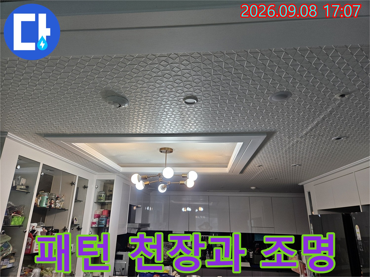 격자 무늬 패턴의 천장과 중앙에 위치한 샹들리에 스타일 조명