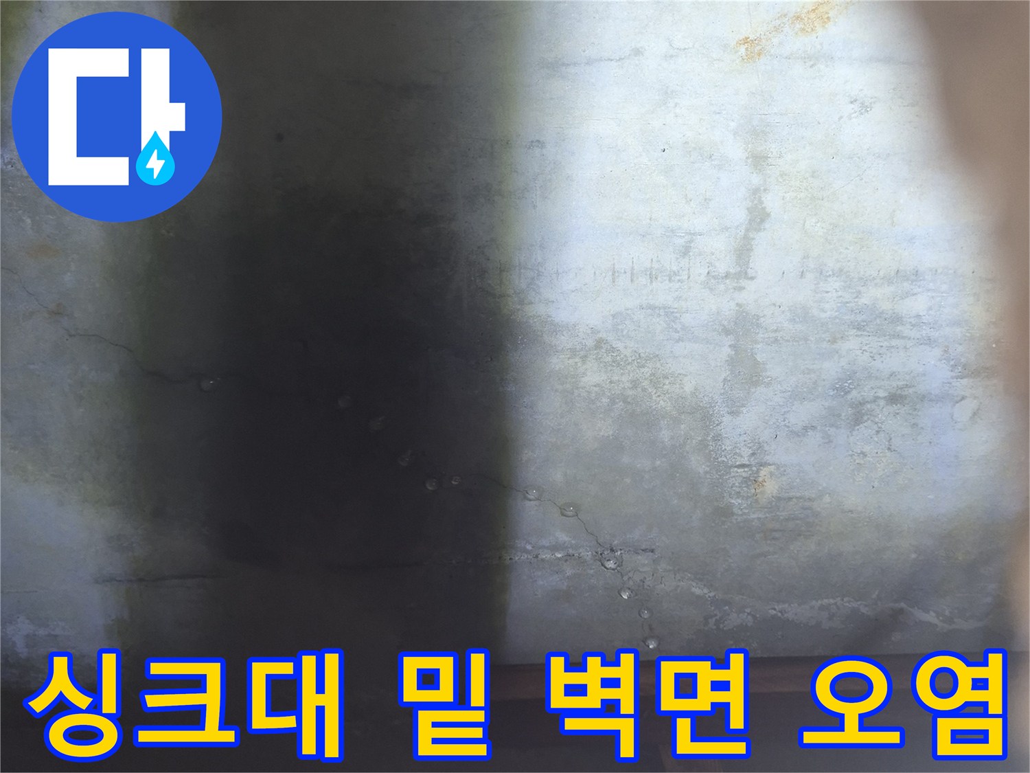 싱크대 하단 벽면의 습기와 곰팡이 흔적을 근접 촬영한 사진