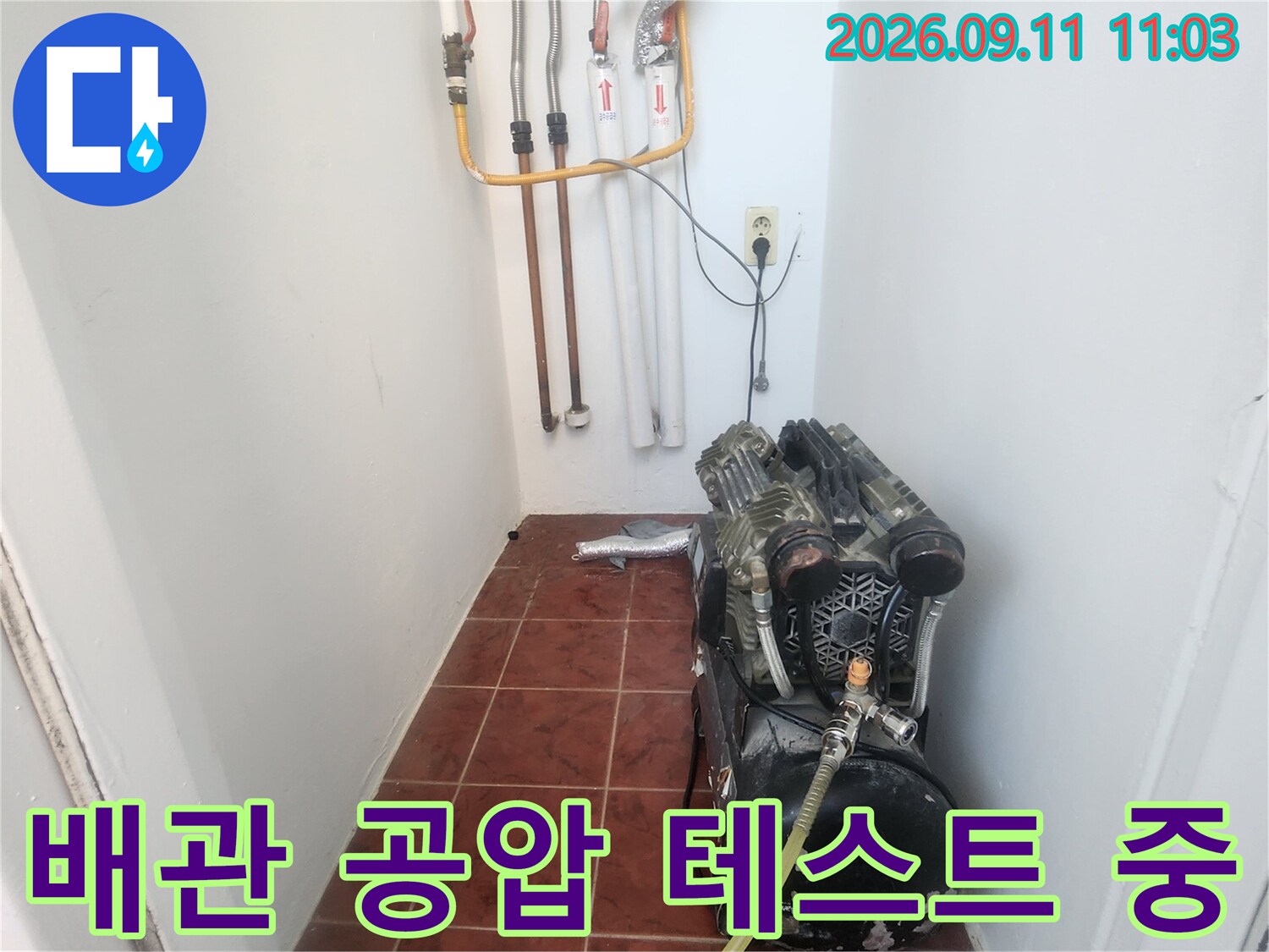 보일러실 하단 배관에 연결된 압력계와 노란색 호스 장비