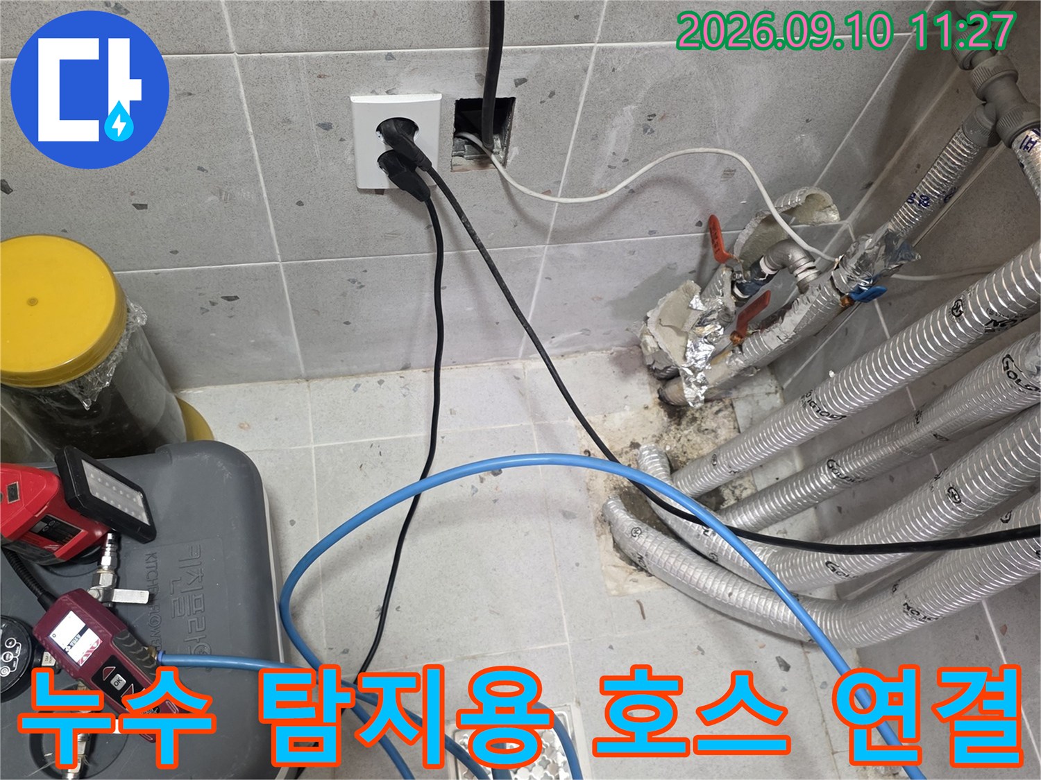 보온재로 감싸진 배관과 연결된 파란색 누수 탐지 호스입니다.