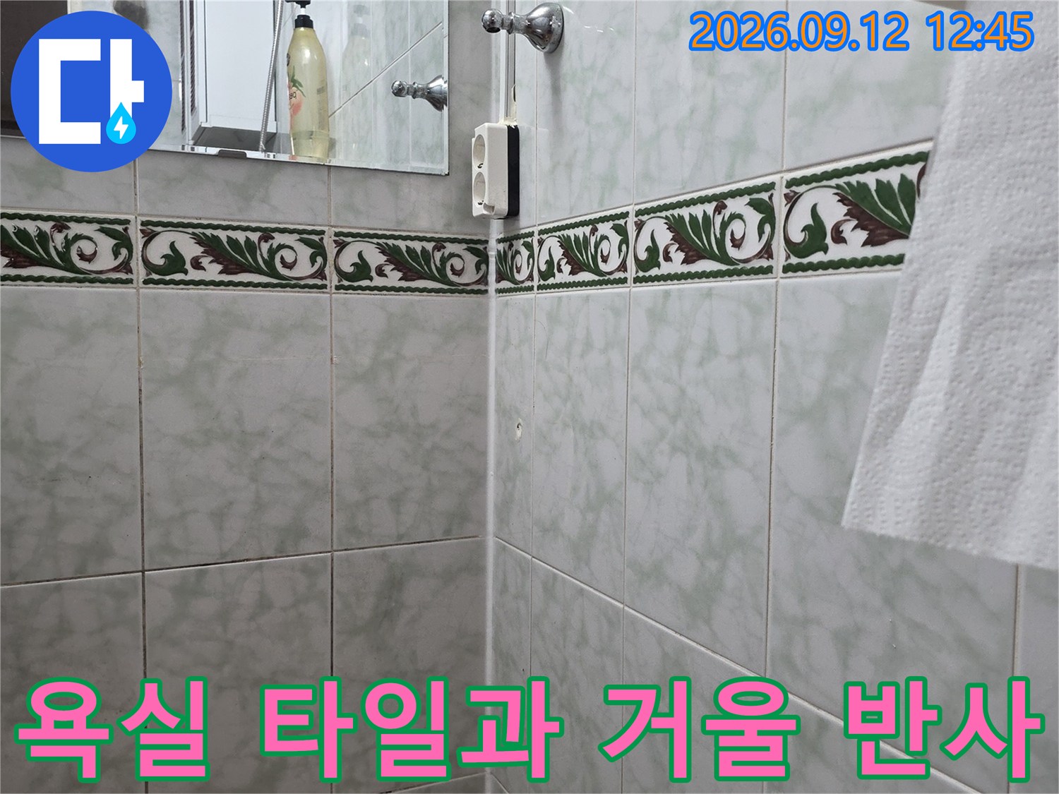 화장실 벽면의 타일 무늬와 거울에 비친 시설물입니다.