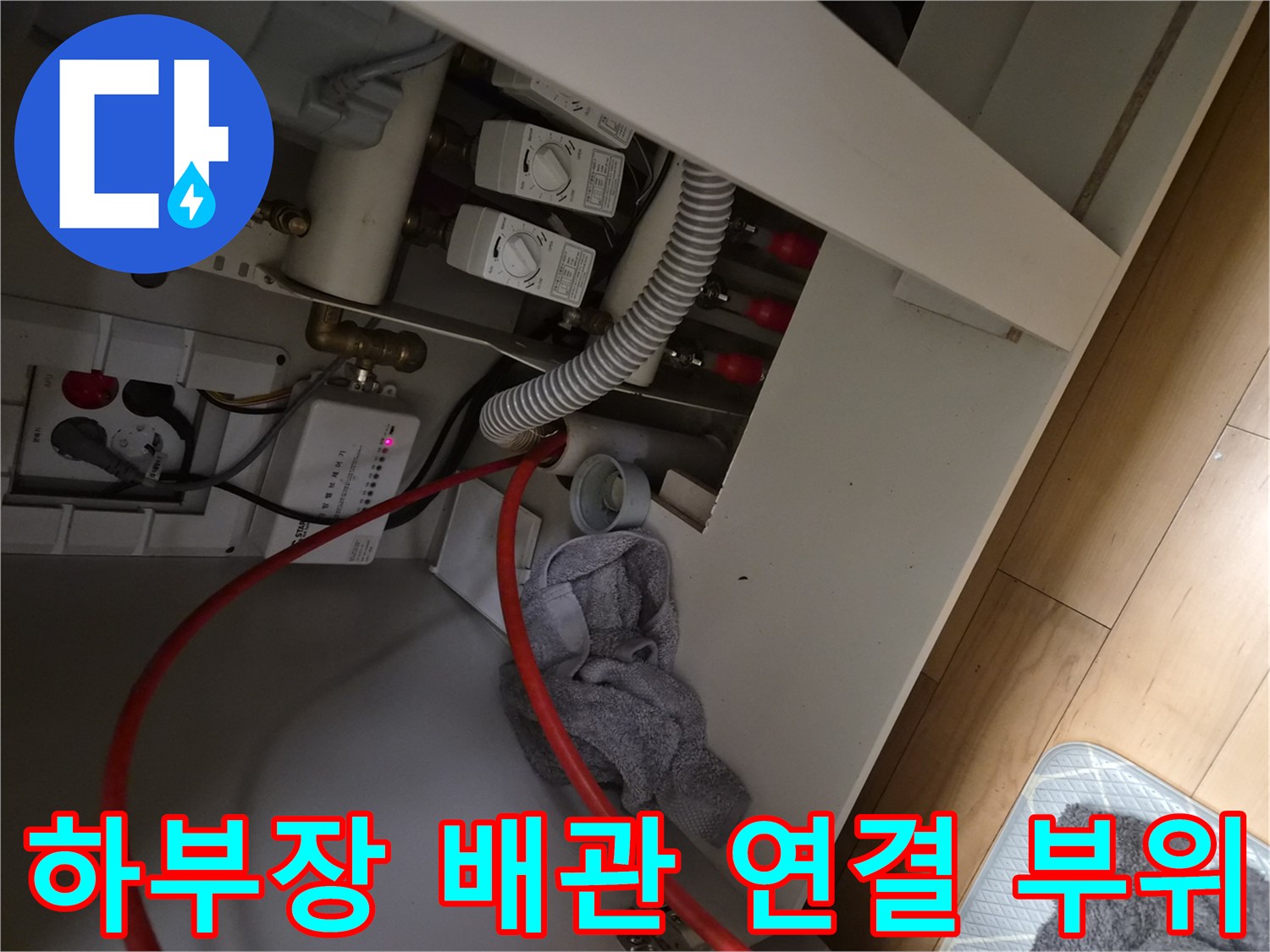 싱크대 아래쪽 급수 밸브와 흰색 배수 호스 연결 상태