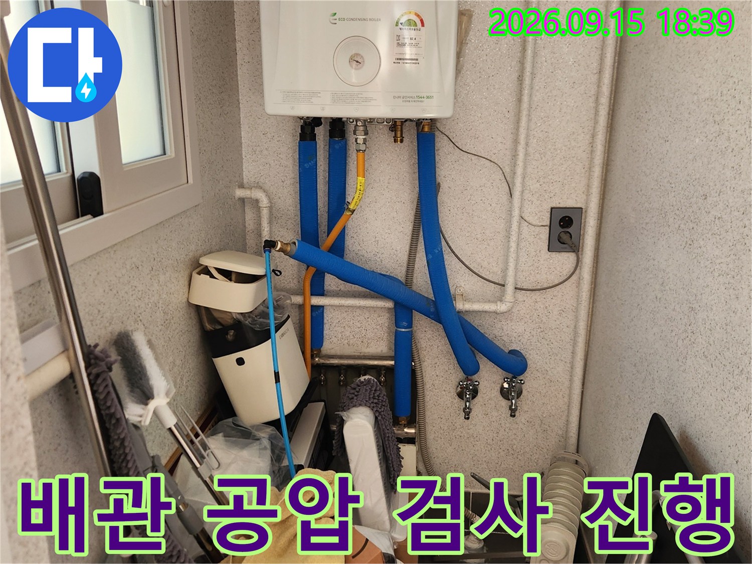 가스보일러 하단에 연결된 파란색 배관과 노란색 연결 부위 상세 사진