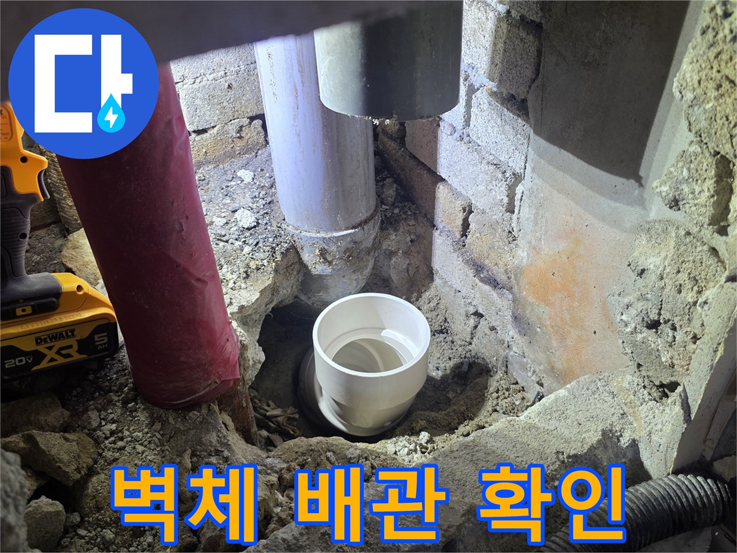 벽면을 파낸 자리에 드러난 배관과 작업용 전동 드릴